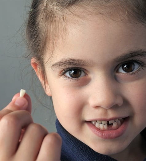 Little girl holding her extracted tooth