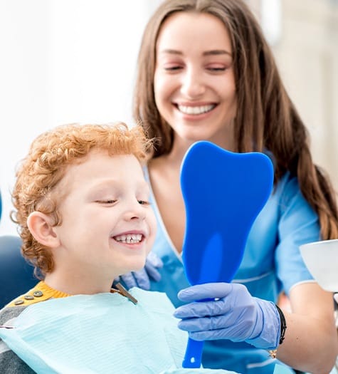 Little boy looking at smile after teeth cleaning